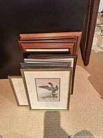 Stack of ten framed prints showing assorted frame finishes and sizes