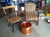 Two chairs side by side and copper pot in front on carpeted floor in a room with other household items.