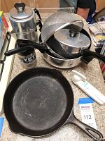 Photo showing the Griswold cast iron skillet, stainless steel cookware with black handles, metal mesh colander, aluminum vintage stove-top coffee pot, Yeti Rambler Closter cooler, white Culinare can opener, and parts of other items.