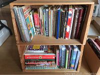 Two wood crates filled with assorted cookbooks, side view showing spines and book titles