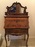 Front view of carved oak secretary desk with attached mirror