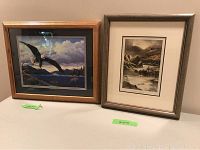 Photo showing both framed prints side-by-side on a table, one with eagle and the other with fisherman and salmon.