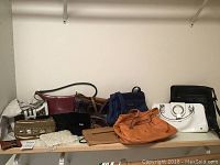 Full view of all purses arranged on shelf showing different styles, colors and brands including Coach, Fossil, and others