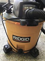 Front view of Ridgid shop vacuum showing yellow tank, RIDGID logo, and the 5.0 HP motor indication.