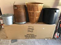 The new in box World Market potting bench with three assorted baskets and buckets placed on top.