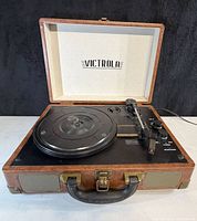 Record player open showing platter, tonearm and controls