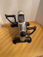 Front view showing digital display, pedals, and resistance knob