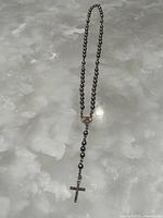 Full view of hematite rosary showing beads, central medal, and crucifix
