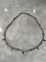 Full view of silver-tone tube choker with spikes