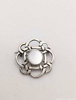 Front view showing mother of pearl cabochon and Celtic knot frame