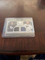 Front view of dual jersey card in case showing both player images and fabric swatches