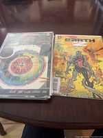 Stack of bagged comics showing board game style Flash cover and Earth 2 #27