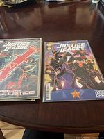 Two stacks of bagged Justice League comics, covers visible