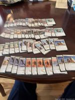 Spread of multiple rows of white Magic: The Gathering cards on table surface