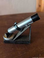 Side view of silver tube magnifier on black angled base