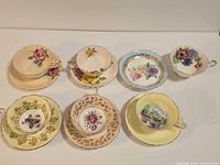 All seven assorted teacup and saucer sets displayed