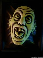 Front view of glow-in-dark 3-D vampire face plaque