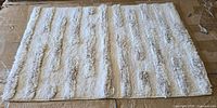 Full view of cream cotton bath rug on surface