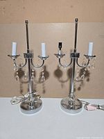 Two identical chrome table lamps without shades
