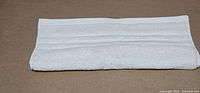 Folded ivory hand towel showing border texture