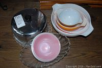 Overall view of bowls including a metal cake cover and glass trays
