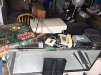 Photo showing Hewlett-Packard scanner, beige corded phone, car stereo cassette deck, and box labeled 'Bells of Christmas'.