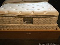 Side view of mattress and box spring on the bed frame showing Golden Rest Ultrasonic 800 mattress label and pull-out drawer on frame with a small ding.