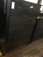 Front view of black wood 6 drawer highboy dresser with metal ring pulls, one pull missing