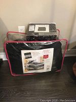 Queen size bedding in packaging showing Playboy brand sheet set and a comforter set with black and beige floral design.