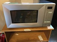 Front view of Simplicity stainless steel microwave showing door and control panel.