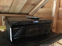 Panasonic DVD player and Pioneer AV receiver placed on a wooden surface under roof beams.