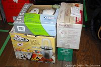 Four boxed small appliances: Hamilton Beech FreshChop food chopper, Westinghouse hand mixer, Miracle blender base, and Graco baby monitor.