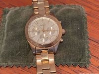Front view of DKNY gold tone chronograph wristwatch on fabric pad