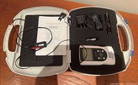 Open case showing device, manual, adapter, lead wire, foam insert