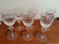 Full set of six crystal wine glasses displayed upright
