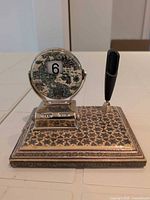 Front view showing map face set to 6, pen holder and inlaid base