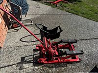 Red hydraulic jack, side view with handle extended