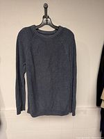 Front view of grey rib-knit sweater on hanger