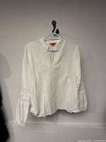 Front view of white Joe Fresh blouse hanging