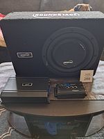 Subwoofer enclosure, amplifier and LC2i unit on table