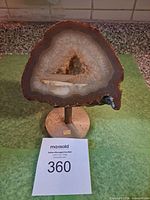 Front view of agate geode slice on stand showing banding, druzy center and overall form