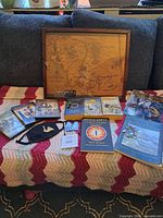 Overview of entire collection on couch showing framed map, books, DVDs, jewellery and accessories