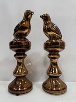 Front view of both amber mercury glass bird statues