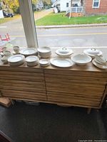 Entire dinnerware set laid out on sideboard showing quantity and pattern