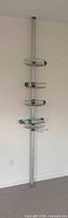 Full view of tension pole shower caddy showing four baskets and floor-to-ceiling design