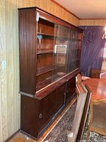 full side view of two-piece cabinet showing glass top and wooden base