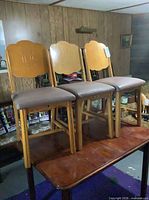 Three solid wood dining chairs on table