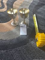 Pair of goblets beside tape measure showing height