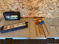 Overview of croquet set on table showing mallets, balls, wickets and bags