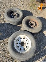 Three of the trailer tires showing tread, rims and overall wear
